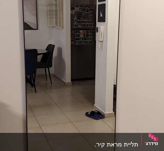 מראה גדולה תלויה על קיר לבן